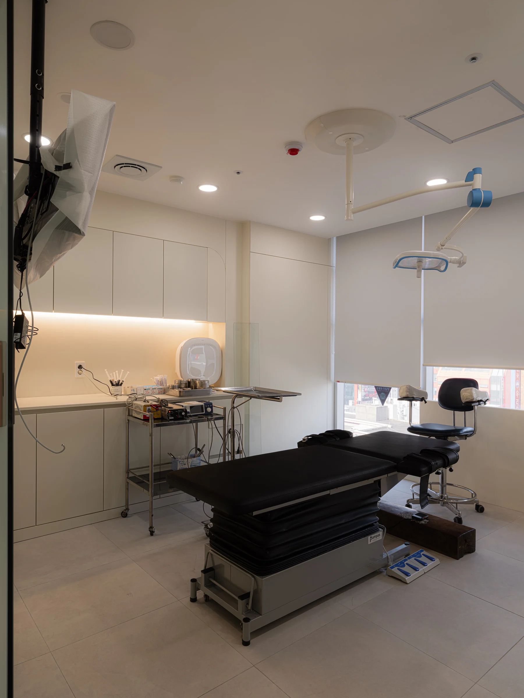 The operating room with a surgical table, overhead surgical lights, and prepared instruments